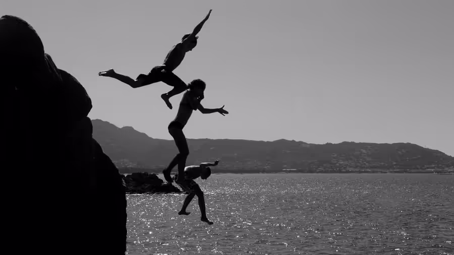 Three people leaping into the water